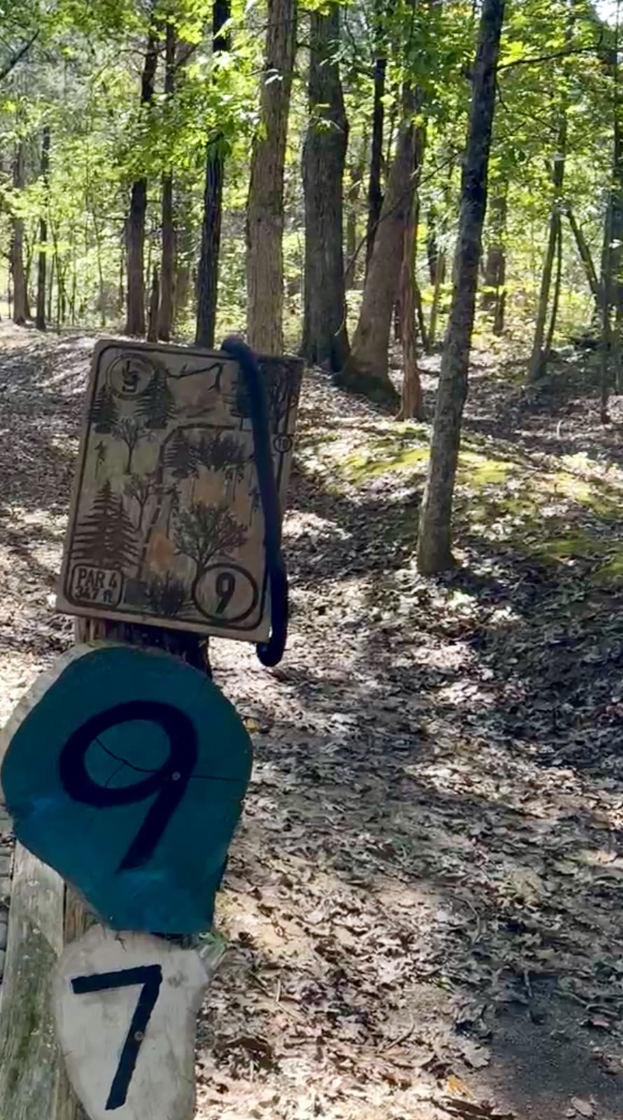 Blue Goose hole 9 tee sign (Par 4, 347 ft) with a black snake draped over the board