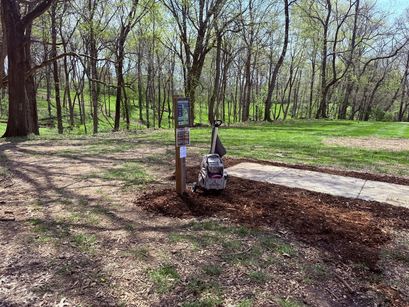East Frankfort Park hole 1 tee pad with Trooper disc golf bag and cart
